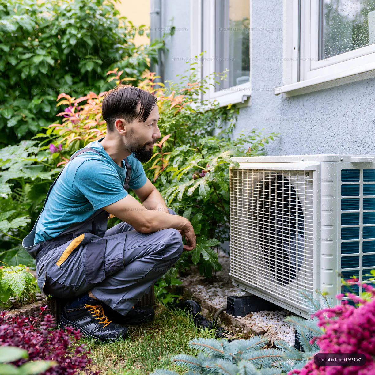 Man inspecting air conditioning unit in garden