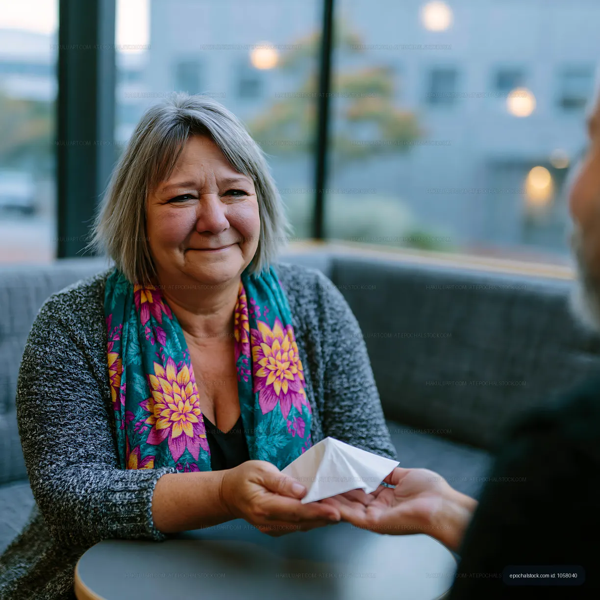 Woman handing a small gift to a man in a cafe