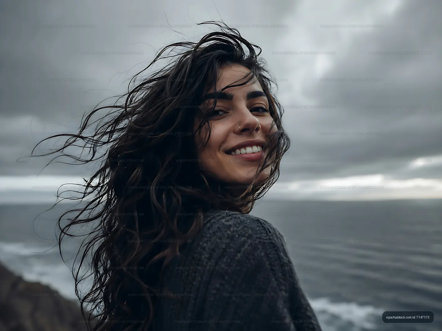 Woman smiling with windblown hair by the ocean
