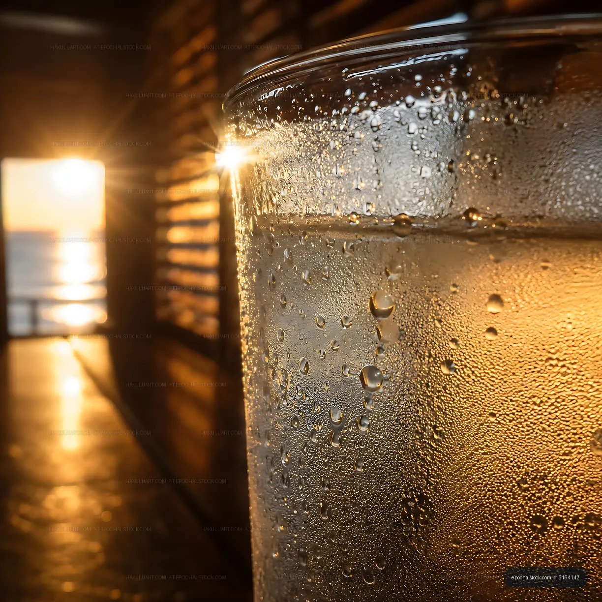 Sunset view through a glass of cold water on a warm evening