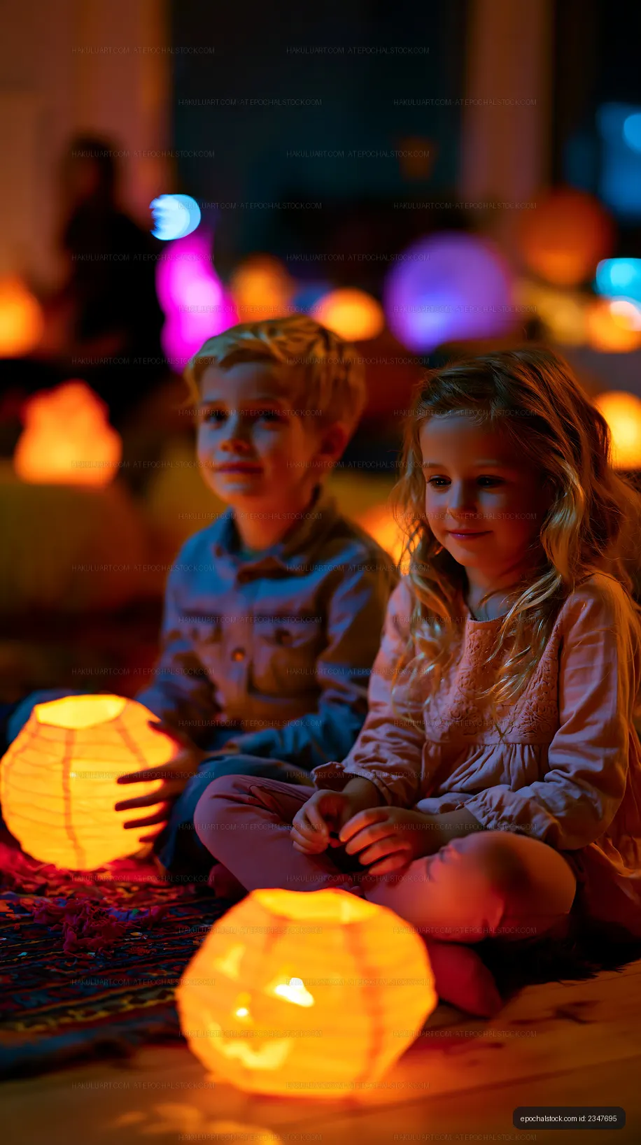 Kids sitting with glowing lanterns at a festival in evening light