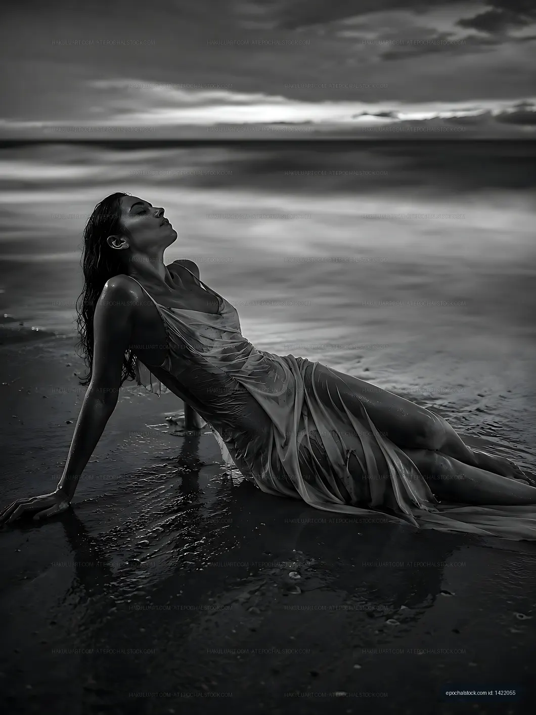 Woman in flowing dress relaxes on beach during sunset