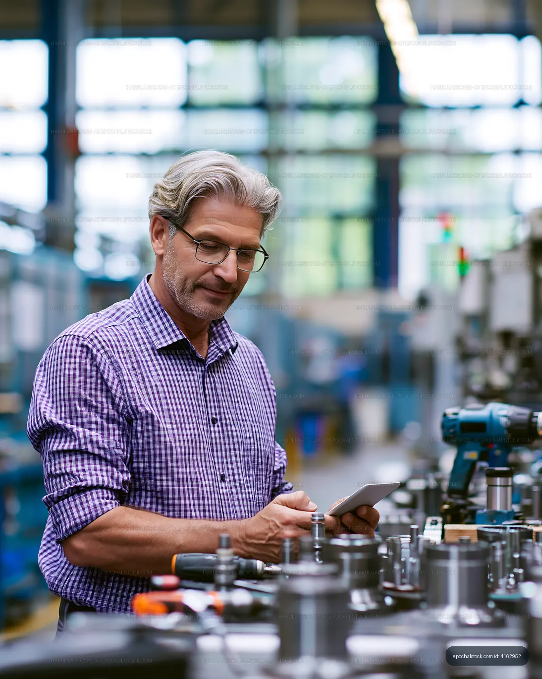 Worker assessing machinery in factory setting