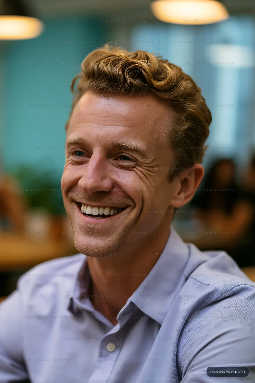 Smiling man with curly hair in a casual setting