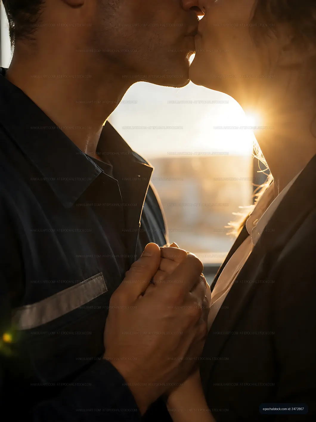 Couple kissing in front of sunset at home