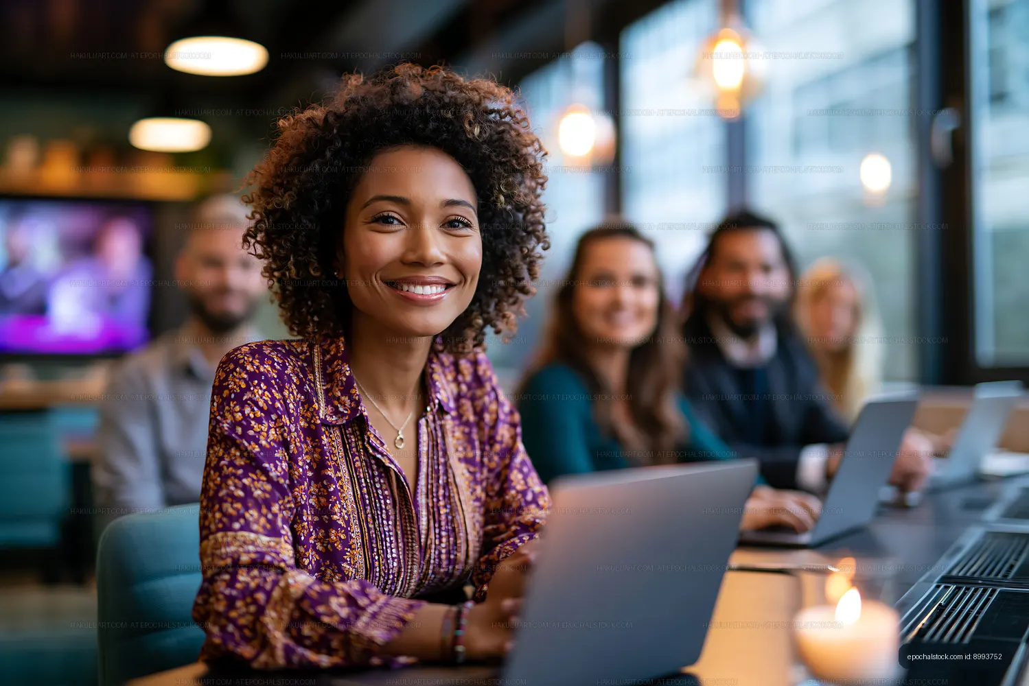 Young woman smiles during group meeting in modern workspace
