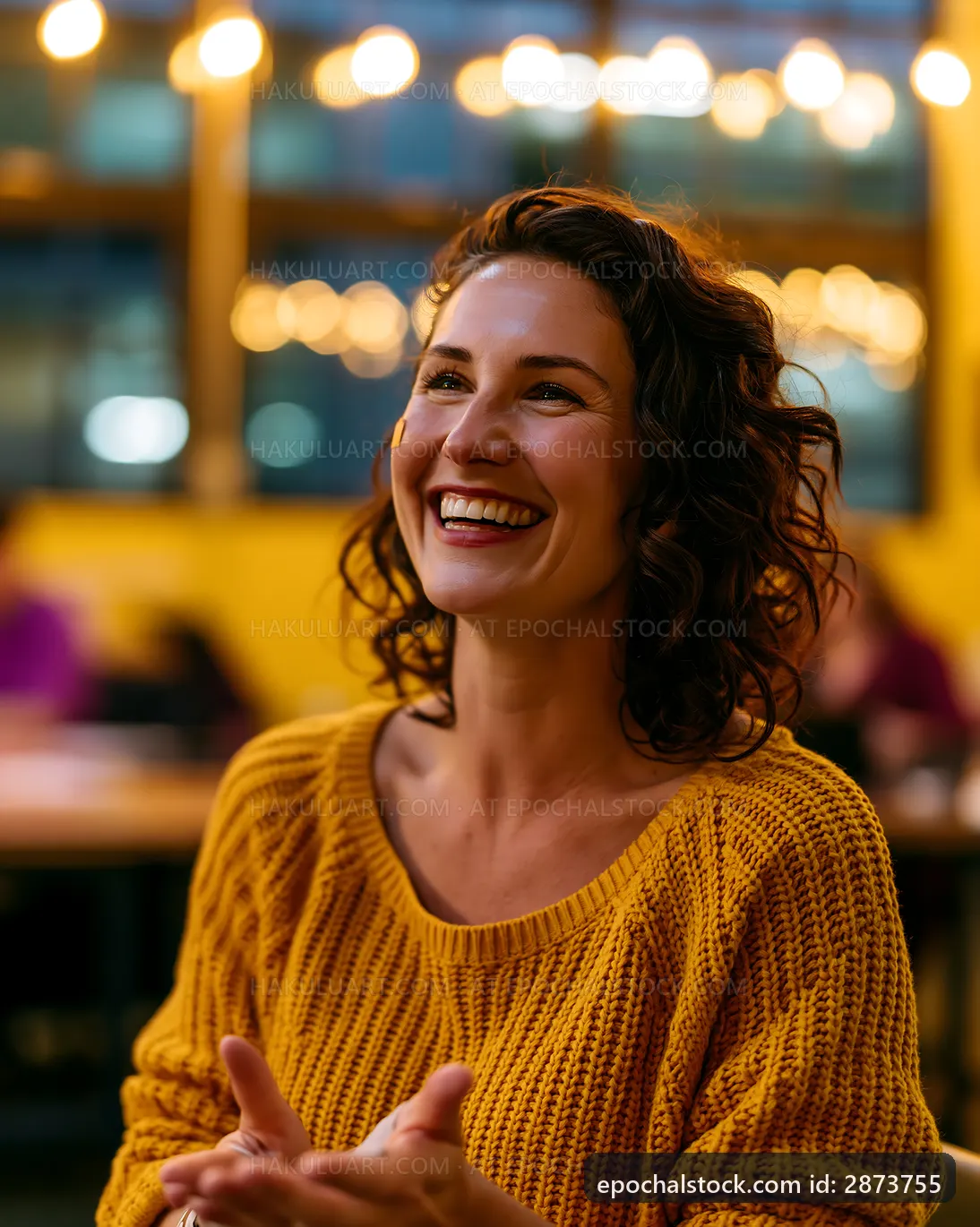 Smiling woman with curly hair in cozy cafe setting