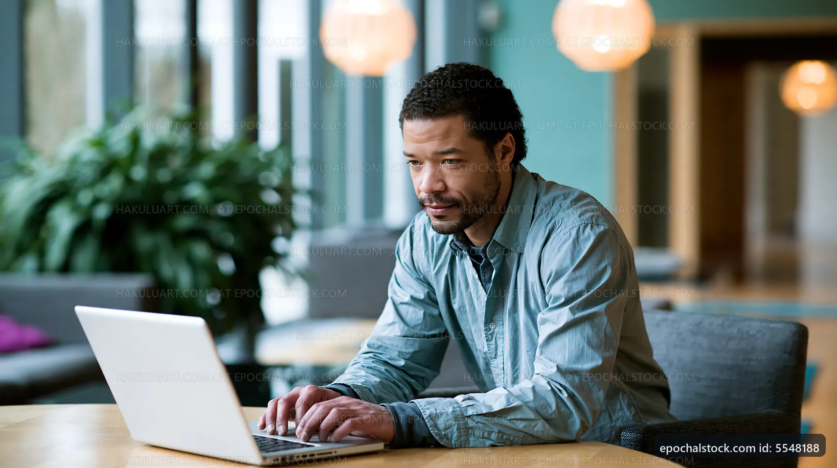 Man working on a laptop in a modern office setting