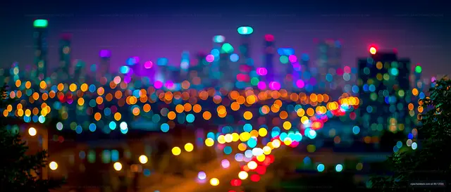 City skyline at night with colorful lights and blurred view