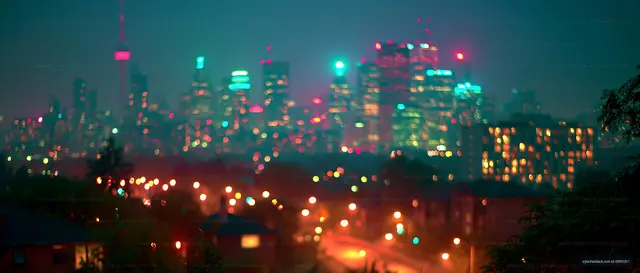 City skyline at night with colorful lights and blurred view