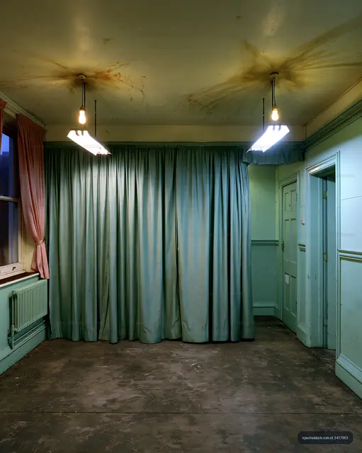 Empty room with green curtains and overhead lights