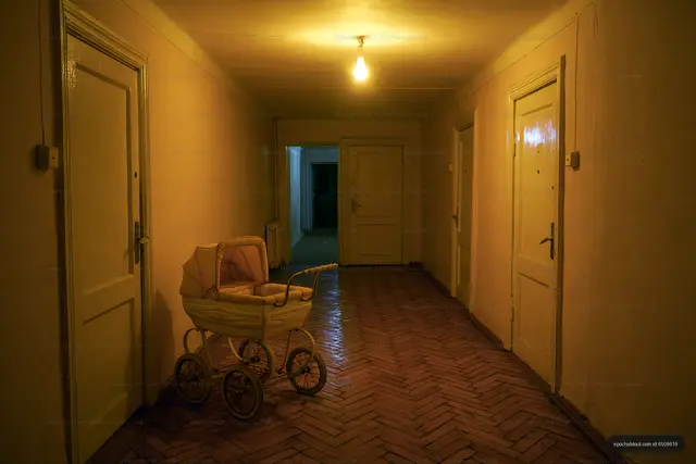 Empty hallway with a vintage baby stroller in a building