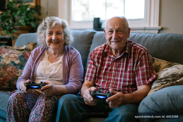 Seniors playing video games together on a sofa