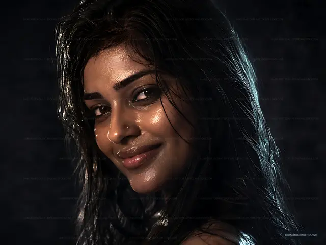Woman with wet hair smiling in dramatic lighting